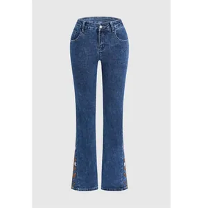 High-waisted blue flared jeans featuring intricate floral embroidery details on side seams.