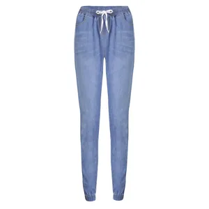 Close-up detail of women's light blue denim joggers with elastic drawstring waist and cuffs