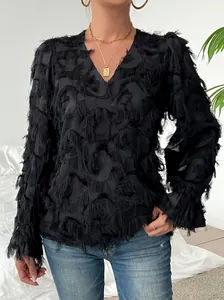 Détail d'une blouse noire à col en V avec une texture unique de franges de plumes