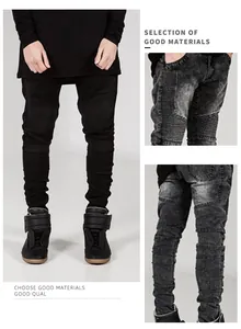 Détail de jean biker noir avec genoux plissés et texture denim délavé à l'acide