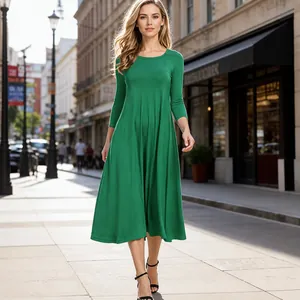 Smaragdgrünes langärmeliges Midikleid aus Baumwolle und Leinen in einer Stadtstraße.