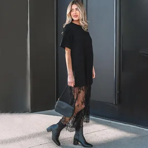 Detail view of a black t-shirt dress featuring an elegant floral lace patchwork skirt hem