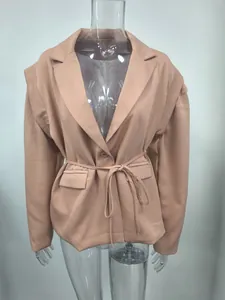 Primer plano de un blazer rosa palo con cinturón de lazo y solapa para mujer