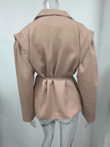 Detalle posterior de blazer beige para mujer con cinturón y hombros plisados