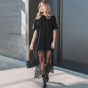 Full view of black t-shirt dress with elegant long lace patchwork hem in daylight