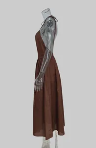Detailed side profile view of an elegant brown backless V-neck maxi dress on a mannequin.