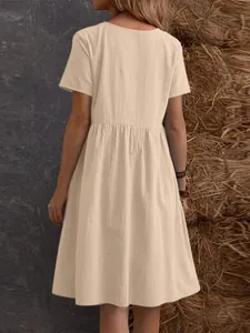 Vista trasera de un vestido de verano de algodón y lino beige con cintura fruncida