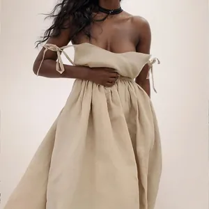 Detail view of an elegant beige off-shoulder maxi dress featuring arm tie bow accents