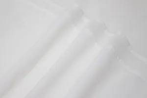 Close-up texture of white pleated fabric showing fine stitching details for elegant dress.