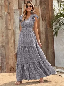 Full view of a floral tiered maxi dress with V-neck and flutter sleeves in a sunny outdoor setting