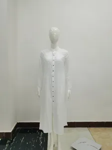 Vue d'une robe longue chemise en mousseline blanche sur un mannequin dans un studio.