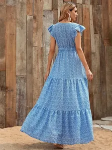 Detailed view of the layered skirt and floral print on this blue V-neck maxi dress.