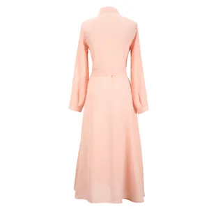 Vue arrière d'une élégante robe longue en mousseline rose à manches longues et ourlet évasé