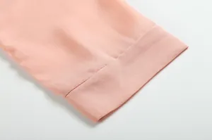 Gros plan sur la manche d'une robe en mousseline rose montrant la texture du tissu