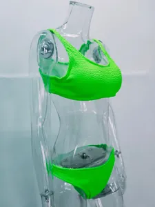 Vista detallada de un conjunto de bikini texturizado verde neón en maniquí transparente