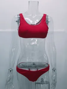 Conjunto de bikini rojo de tela arrugada en maniquí transparente con detalles