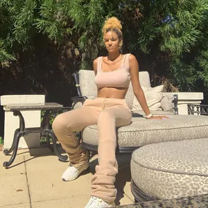 Outdoor lifestyle shot of women's comfortable beige plus size high-waist stacked joggers