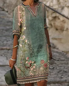 Detail of a green bohemian V-neck dress with vintage floral ethnic prints for women