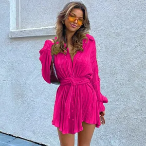 Vibrant magenta pleated long-sleeve shirt dress with adjustable waist tie detail.