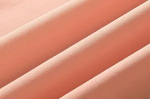 Vue macro détaillée montrant la texture douce et les plis élégants du tissu en mousseline rose