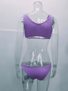 Vista trasera de un bikini de dos piezas morado fruncido en un maniquí transparente