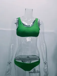 Vista detallada de un conjunto de bikini verde brillante en tela rugosa en un maniquí