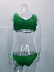 Vista trasera de un conjunto de bikini verde de tela rugosa en un maniquí transparente