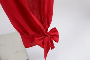 Close-up of a red cotton garment sleeve featuring a stylish decorative bow tie.