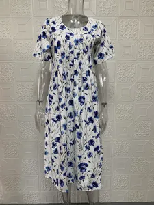 Dettaglio della stampa floreale blu su abito estivo bianco a maniche corte da donna