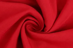 Macro detail of soft red cotton fabric showing fine textile weave and texture
