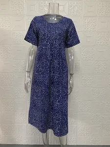 Dettaglio di un abito lungo casual a maniche corte con stampa a pois bianchi su blu scuro
