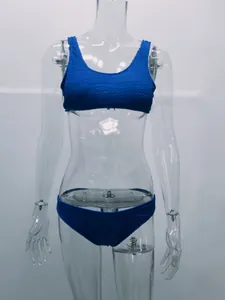 Detalle del conjunto de bikini azul de tela arrugada en maniquí transparente.