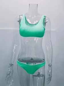 Detalle de un conjunto de bikini de dos piezas verde menta texturizado en un maniquí transparente