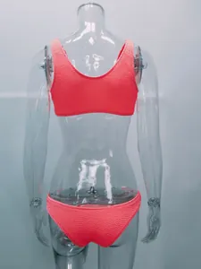 Vista trasera de bikini para mujer en tela arrugada rosa coral sobre maniquí transparente