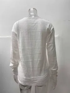 Vista posteriore di una maglia bianca a coste a maniche lunghe con bottoni dorati