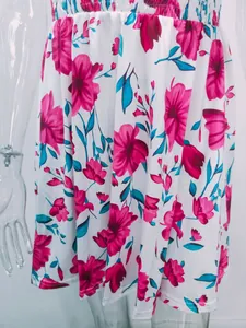 Close-up detail of an elegant white summer dress with a vibrant pink floral print.