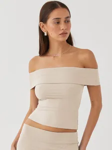 Detail showing the fit of a beige off-the-shoulder fitted summer top on a model