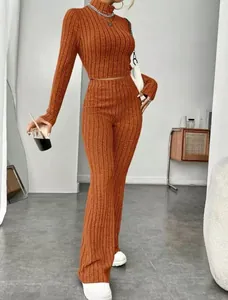 Two-piece ribbed knit set featuring rust-colored high-neck crop top and flared pants