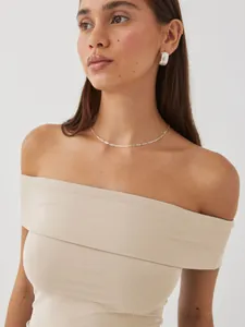 Close-up of a women's beige off-the-shoulder ribbed tube top showing fit