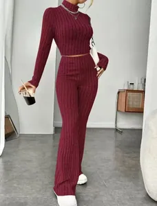 Close-up of wine red ribbed knit fabric on a slim-fit crop top and high-waisted flared pants
