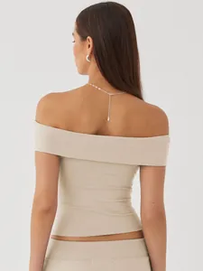 Detailed back view showing the shoulder line of a beige off-the-shoulder slim fit sexy top