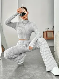 Lifestyle shot of a grey ribbed knit set showing the fit and fabric texture in a room