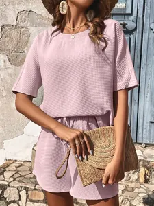 Détail d'un ensemble deux pièces mauve en maille gaufrée pour femme en extérieur
