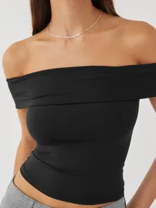 Detail of black off-the-shoulder crop top featuring elastic ribbed fabric texture