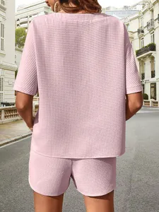 Détail arrière d'un ensemble deux pièces rose en maille gaufrée avec manches chauve-souris.