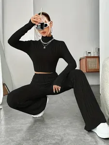 Fashionable black ribbed knit set with crop top and wide-leg trousers on model