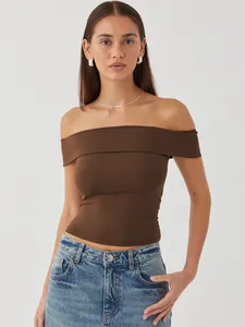 Detailed studio view of the stylish brown off-the-shoulder top worn by a fashion model.