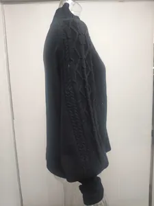 Side view detail of elegant black knitted sweater with cable knit lantern sleeves.