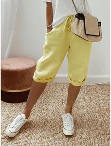 Detailansicht einer gelben Leinen-Caprihose mit Kordelzug am Model