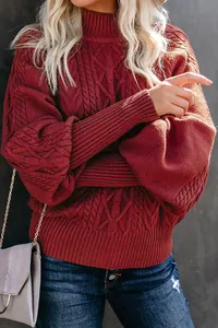 Detailed view of burgundy cable-knit sweater with stylish lantern sleeves and ribbed cuffs